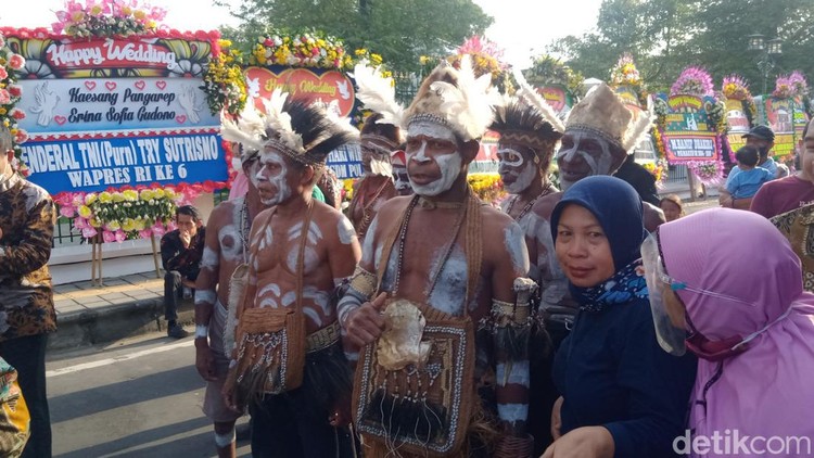 Rombongan asal Kabupaten Asmat, Papua, di depan Puro Mangkunegaran, Solo, untuk menghadiri tasyakuran pernikahan Kaesang Pangarep dan Erina Sofia Gudono, Minggu (11/12/2022). Rombongan asal Kabupaten Asmat, Papua, di depan Puro Mangkunegaran, Solo, untuk menghadiri tasyakuran pernikahan Kaesang Pangarep dan Erina Sofia Gudono, Minggu (11/12/2022).
