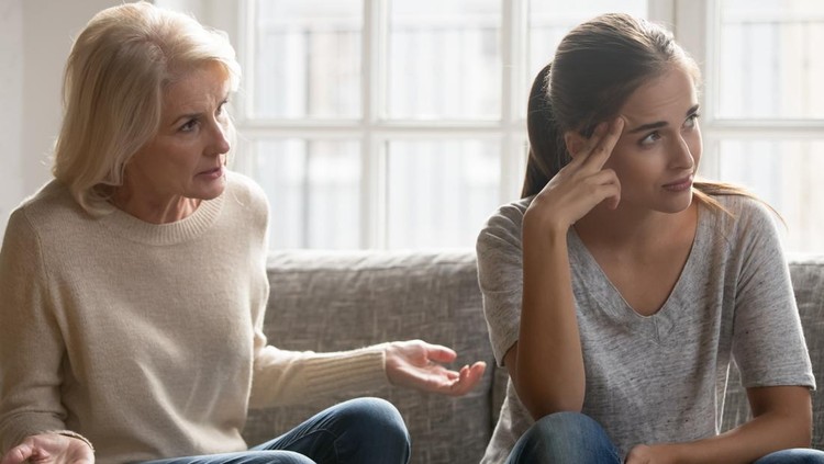 Tired annoyed millennial woman lose patience ignore senior anxious mom talking lecturing at home, elderly middle-aged authoritative mother sit on couch scolding moralizing grownup adult daughter