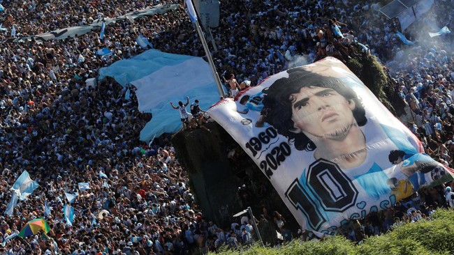 Soccer Football - FIFA World Cup Final Qatar 2022 - Fans in Buenos Aires - Buenos Aires, Argentina - December 18, 2022  General view as Argentina fans with a Diego Maradona banner celebrate after winning the World Cup by the Obelisco REUTERS/Agustin