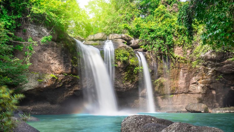 Travel to the beautiful waterfall in deep forest, soft water of the stream in the natural park at Haew Suwat Waterfall at Khao Yai National Park, Thailand