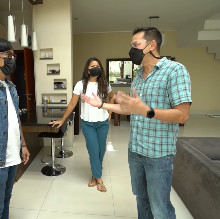 <p>Lalu, ada minibar kecil dan dapur di bagian lain ruang tengah. Masih dengan tema minimalis, dapurnya pun terlihat rapi berdekorasi furnitur putih, ya Bun. (Foto: YouTube/Taulany TV)</p>