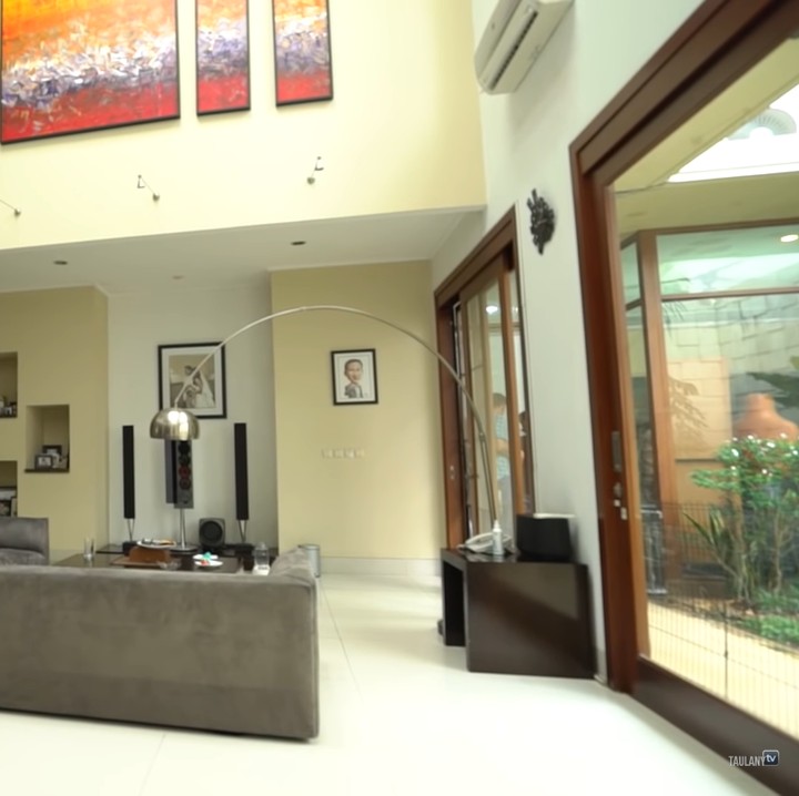 <p>Tidak banyak barang di dalam rumah Ari Wibowo sehingga semakin memberikan kesan lapang. Cat tembok berwarna terang dan langit-langit yang tinggi pun membuat rumah Ari Wibowo terlihat semakin luas. (Foto: YouTube/Taulany TV)</p>