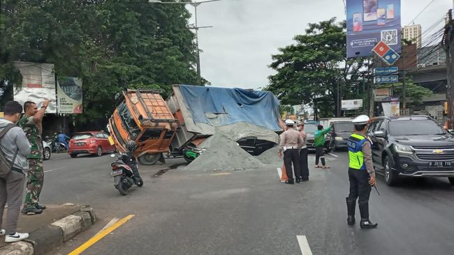 Truk bermuatan pasir terguling dan menimpa mobil dinas milik TNI AD di Jalan Raya Cibubur pada Jumat (23/12) pagi tadi.