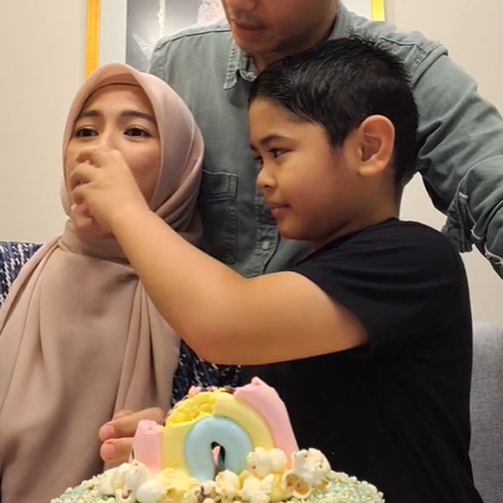 <p>Dude kemudian meminta putra mereka untuk memberikan suapan kue ulang tahun untuk sang Bunda. Alyssa tak kuasa menahan senyum setelah mendapatkan suapan dari Ariendra. (Foto: Instagram @ichasoebandono & @dude2harlino)</p>