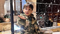 <p>Muhammad Khaleed Al-Fatih tampak begitu terkesima dengan butiran salju yang turun dari langit. Bikin gemas, ia mencoba untuk menangkap salju di tangannya nih. (Foto: Instagram @lyravirna)</p>