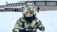<p>Tengok saja potret Khaleed yang asyik menikmati suasana musim dingin di Turki. Bocah kelahiran 21 Agustus 2020 ini justru duduk di atas salju untuk bermain. Saking gemasnya, Lyra pun menyebut Khaled 'si boneka Korea umi.' (Foto: Instagram @lyravirna)</p>
