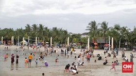 FOTO: Tertutup Awan Mendung, Pantai Ancol Tetap Ramai Pengunjung