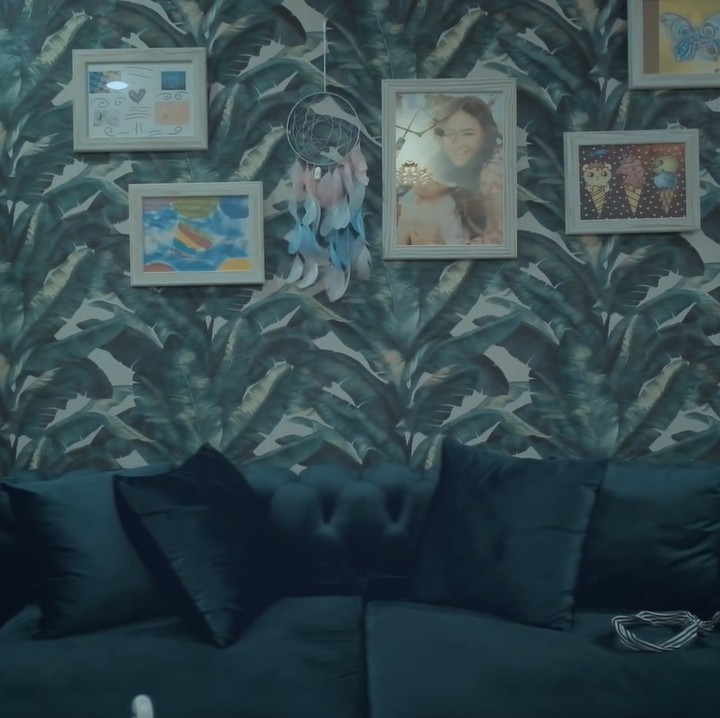 <p>Di ruang tamu rumah Marshanda, terdapat sofa hijau yang satu tema dengan wallpaper hijau di belakangnya. Di dinding juga terpasang hasil <em>dreamcatcher</em> hasil karya putri semata wayangnya, Sienna. (Foto: YouTube/MARSHED)</p>