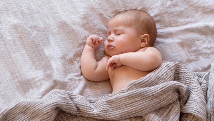 Close-up of sleeping baby on the bed with copy space. New family and baby sleep concept
