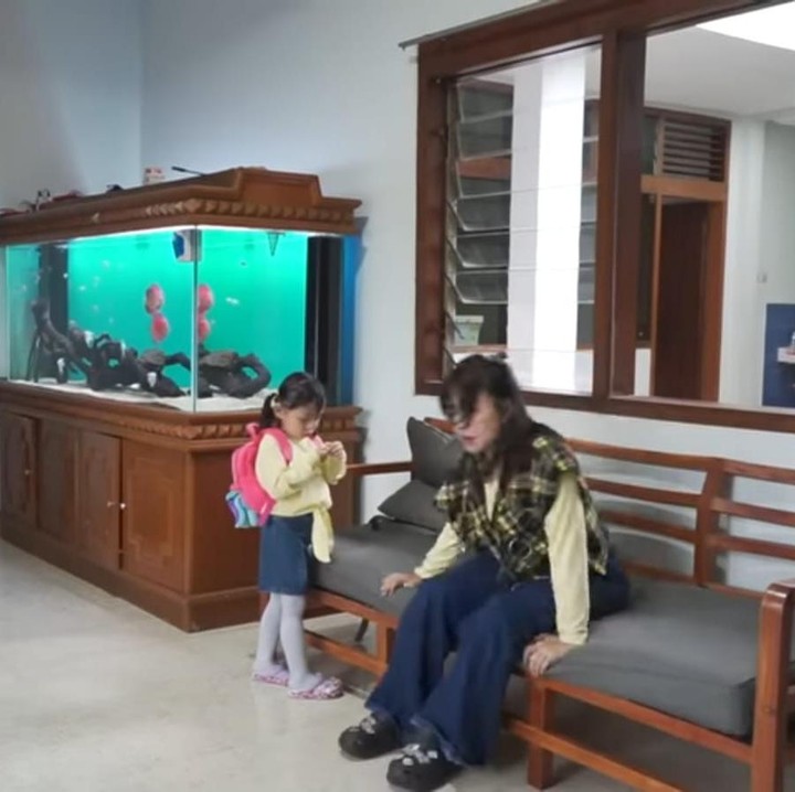 <p>Ruang tamunya pun tampak sederahana dilengkapi dengan beberapa sofa berwarna abu-abu dan dilengkapi dengan akuarium yang cukup besar, Bunda. (Foto: YouTube Queen Lala)</p>