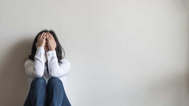 1020849406 Anxiety disorder menopause woman, stressful depressed emotional person with mental health illness, headache and migraine sitting feeling bad sadly with back against wall on the floor in domestic home