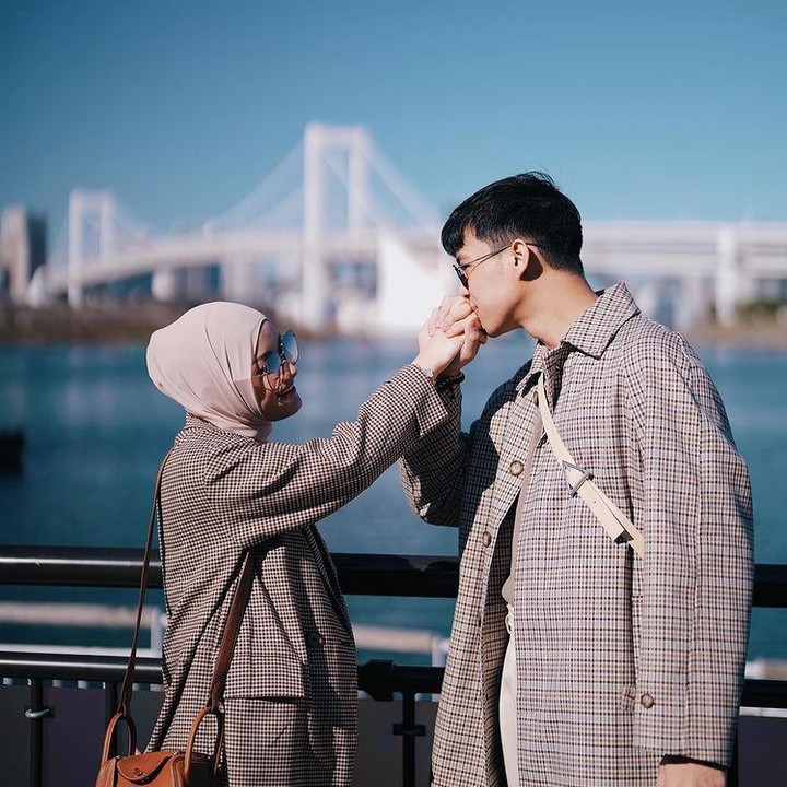 <p>Dinda dan Rey kompak mengenakan baju dengan motif dan warna senada nih. Keduanya juga mengunggah pose romantis mereke dengan pemandangan sungai Jepang. (Foto: Instagram @dindahw)</p>