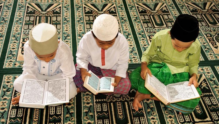 mother and kid reading quran together at home