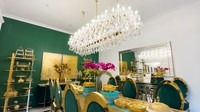 <p>Di ruang makan, Tasyi memberikan warna hijau tua dan emas serta hiasan lampu gantung kristal yang menambahkan kesan mewah. Mulai dari meja hingga dekorasinya Tasyi memilih custom, lho Bun. (Foto: YouTube/Tasyi Athasyia)</p>