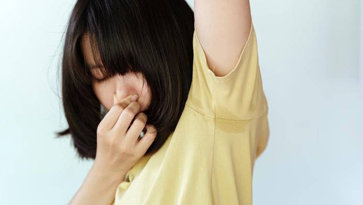 Ilustrasi Anak Bau Badan The woman in the yellow shirt covered her nose with her hands because she was sweating in her armpits and had a bad smell. Health care concept.