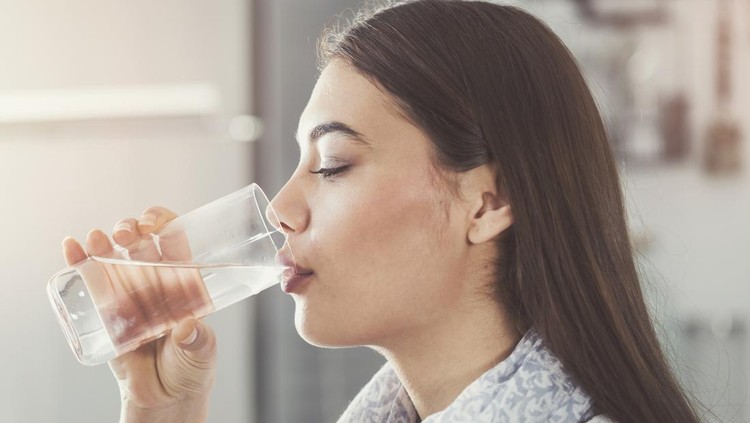 Ilustrasi wanita minum air putih atau mineral