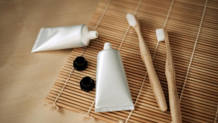 decorating handmade toothpastes and wooden brush on wooden table