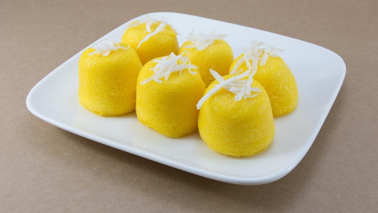 Palm cake with flower on white dish.