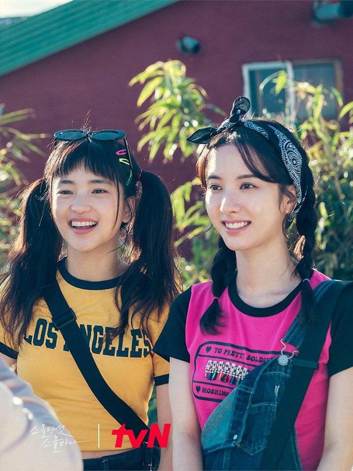 Drama 2521 selalu menunjukkan gaya retro yang khas kepada para tokohnya, termasuk baju berwarna cerah yang digunakan Na Hee Do dan Ko Yu Rim. Mereka juga menata rambut yang ikonik dengan model kepang dan kuncir dua./ Foto: metro.style