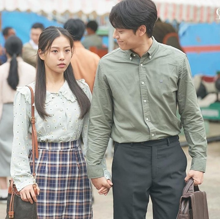 Busana retro yang dikenakan Kim Myung Hee di drama Youth of May terlihat unik. Ia mengenakan blus berkerah motif polkadot dengan rok kotak-kotak yang tampak bentrok. Foto: imdb.com