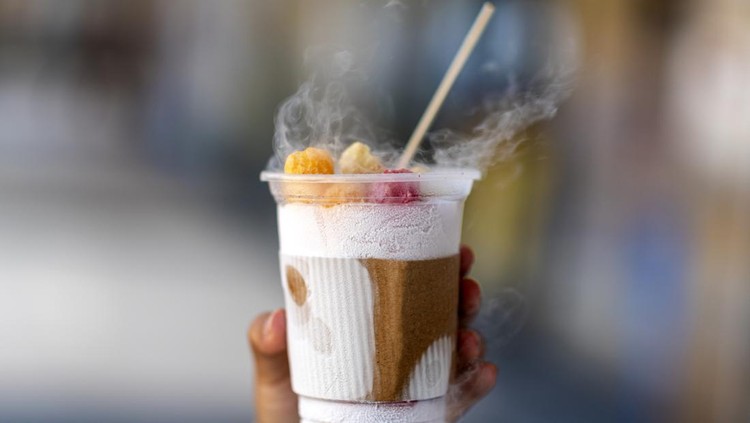 Ilustrasi Chiki Ngebul A view of an employee preparing a cup of dragon's breath cereal dessert at a food stand.