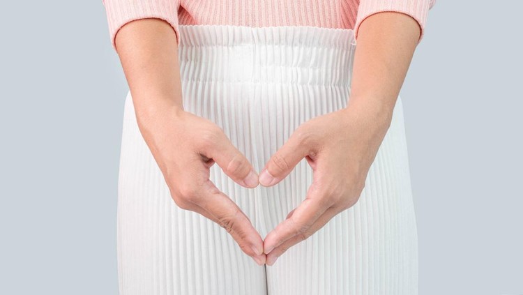 Close up view of young woman and Hand is a symbol of heart over her crotch. Feminine hygiene concept.