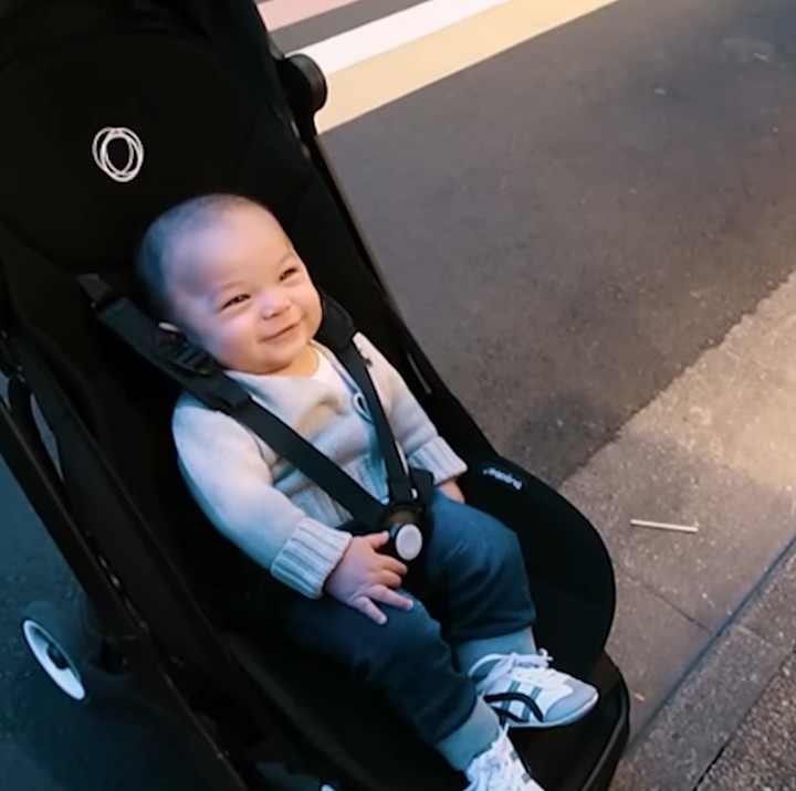 <p>Sesampainya di Kyoto, Baby Izz tampak sangat menikmati suasana liburan ketika dibawa memakai <em>stroller.</em> Ia memamerkan senyumnya yang manis. (Foto: YouTube Nikita Willy Official)</p>