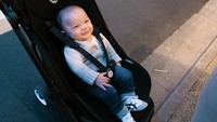 <p>Sesampainya di Kyoto, Baby Izz tampak sangat menikmati suasana liburan ketika dibawa memakai <em>stroller.</em> Ia memamerkan senyumnya yang manis. (Foto: YouTube Nikita Willy Official)</p>