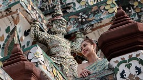 img-title FOTO: Kemilau Pakaian Tradisional dan Pesona Kuil Wat Arun Bangkok