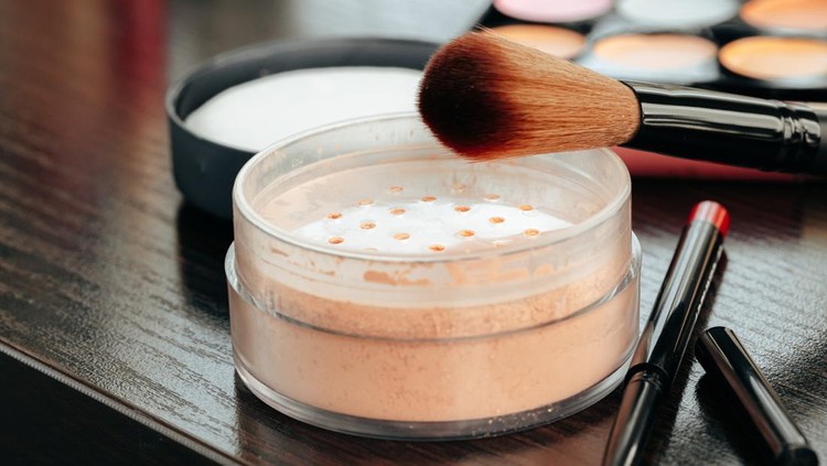 Open loose powder container on table close up photo