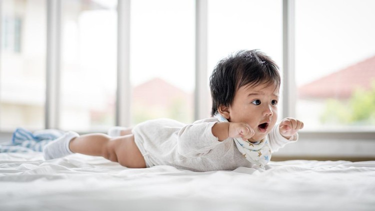 Baby playing with toy and teddy bear at home with happiness.