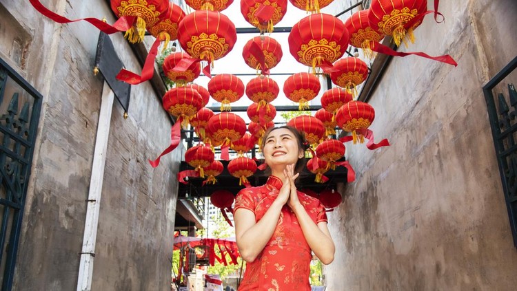 Beautiful Asian woman, model, wearing traditional red cheongsam qipao dress holding  in China Town for Chinese new year concept.