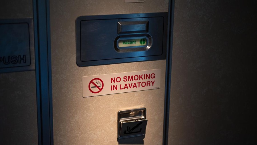 Ilustrasi Toilet Pesawat Door of Vacant lavatory in airplane with No smoking sign, close up.