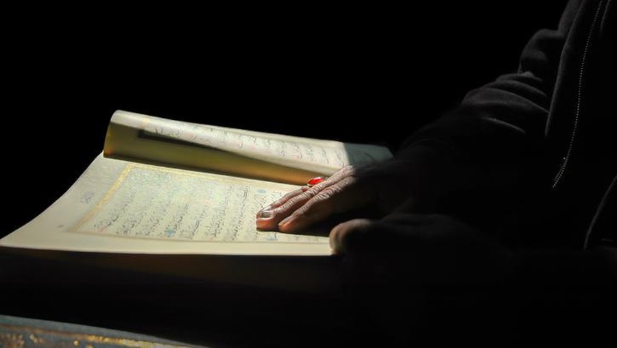 Seorang muslim membaca Al-Qur'an sebelum tidur.