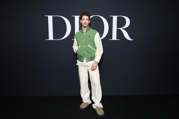 Nuansa kasual juga ditampilkan Manu Rios. Aktor yang melejit berkat serial Elite tersebut tampil modis lewat padanan varsity jacket dengan celana putih. Foto: Getty Images for Christian Dior/Pascal Le Segretain