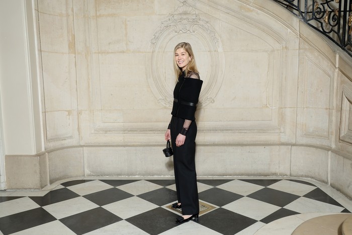 Cape dapat jadi statement pada kombinasi blus transparan dan celana hitam seperti ditampilkan Rosamund Pike. Foto: Getty Images for Christian Dior/Pascal Le Segretain