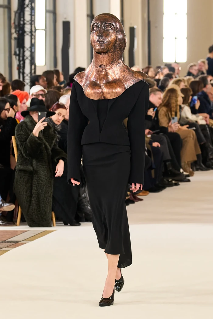 Setelan rok yang klasik jadi nyentrik ketika diperagakan dengan topeng. Foto: Filippo Fior/Gorunway/Vogue