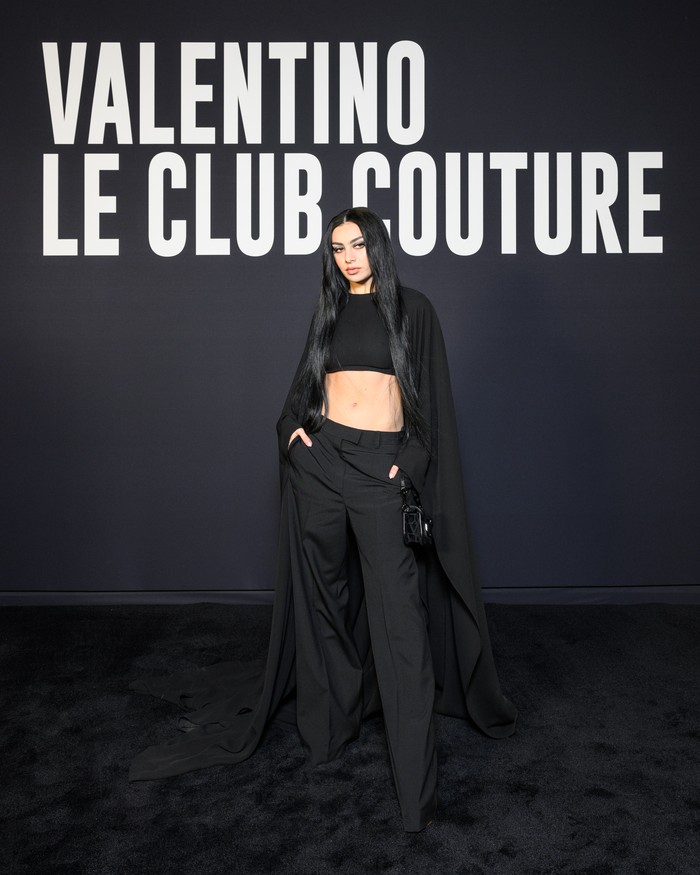 Crop top model cape yang menyapu lantai jadi unsur dramatis dalam gaya serba hitam Charlie XCX. Foto: Valentino/SGPItalia
