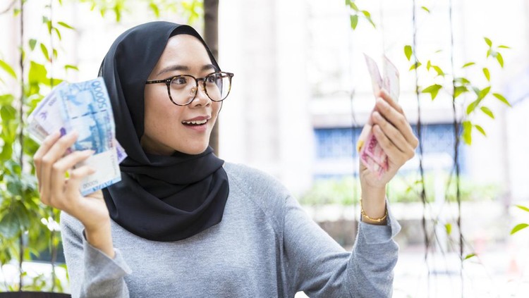 963399650 Malaysian Girl wearing hijab, rejoicing her first salary and counting cash