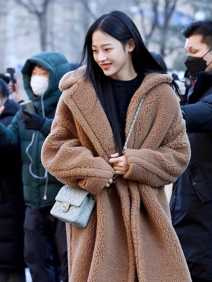 Looks musim dingin dari Min Ji bersama brand Chanel. Inner berwarna hitam polos dengan jaket coklat, disertai hand bag berwarna biru muda yang membuat vibes Min Ji menjadi elegan tetapi tetap cerah. Sangat cantik, bukan?/ Foto: XSportNews