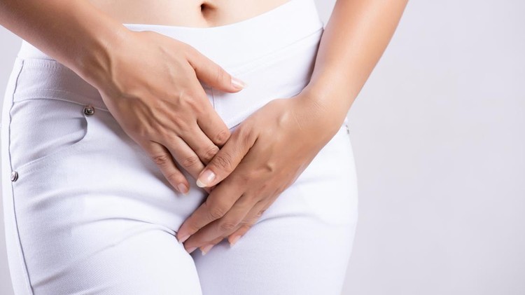 1162756168 Young woman having painful stomachache with hands holding pressing her crotch lower abdomen. Medical or gynecological problems, healthcare concept