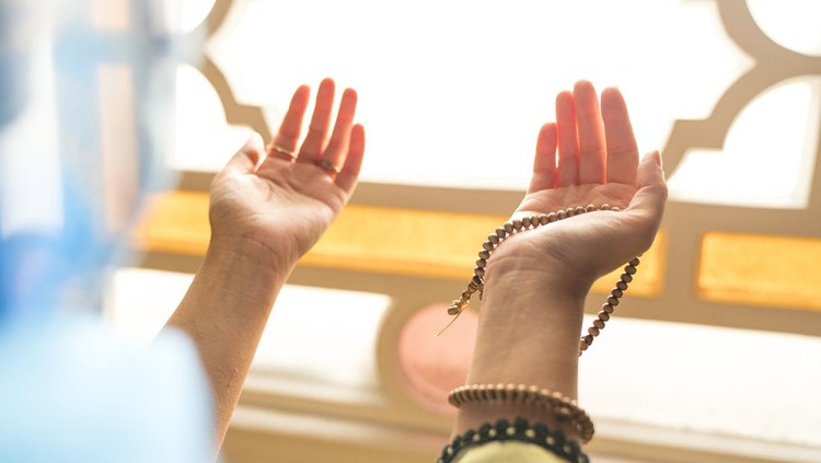 Ilustrasi Berzikir di Bulan Rajab Muslim woman in headscarf and hijab prays with her hands up in air in mosque.Religion praying concept.