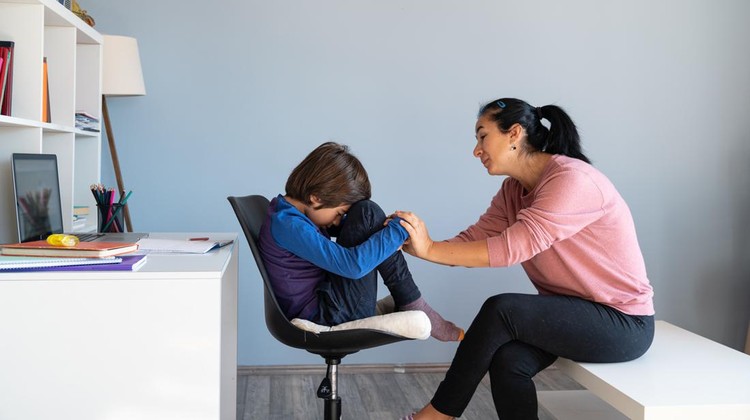 Ilustrasi Anak Depresi Photo of mother talking to her bored schoolboy son having online education during Coronavirus pandemic quarantine. Mother has black hair and is asian. Shot indoor with a full frame mirrorless camera.
