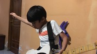 <p>Sebagai orang tua sekaligus musisi, Eross tak keberatan ketika harus mengajarkan El Pitu bermain gitar. "Sementara gaya dan monyongnya dulu," kata Eross kala itu. (Foto: Instagram: @erosscandra)</p>