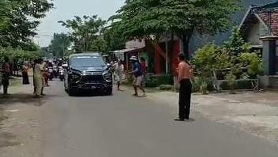 Tangkapan layar pengendara mobil yang menyebarkan uang di jalan Tangkapan layar pengendara mobil yang menyebarkan uang di jalan