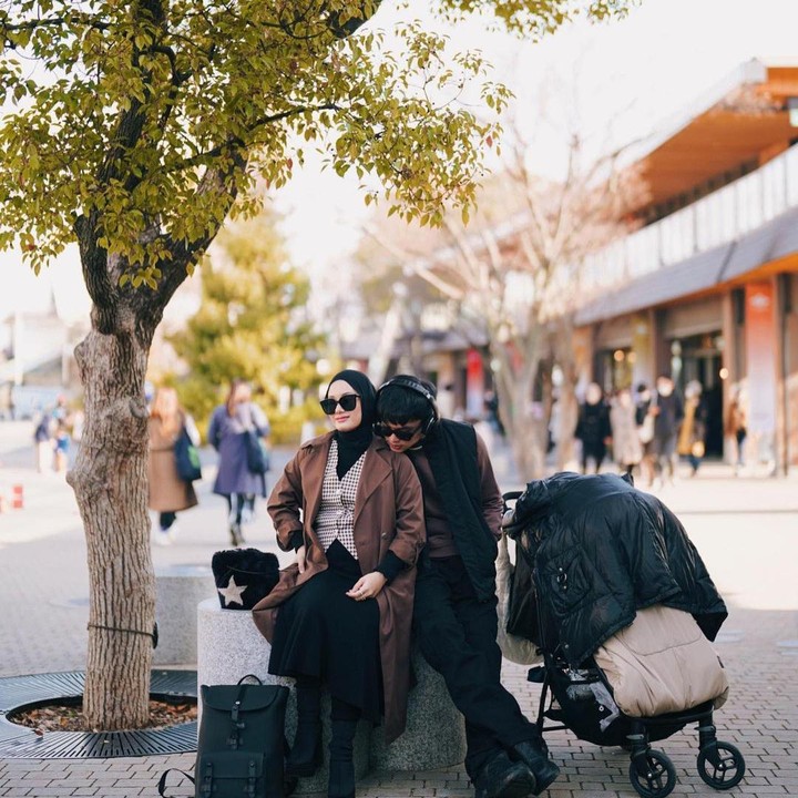 <p>"Ga mau osaka, maunya odinda." tulis Rey Mbayang di caption fotonya dengan pose manja menangkupkan dagu di pundak Dinda dan stroller baby Shaka di sampingnya. (Sumber: @rey_mbayang)</p>