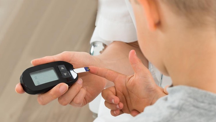 Close-up Of Doctor Measuring Blood Sugar Of Child Patient With Glucometer
