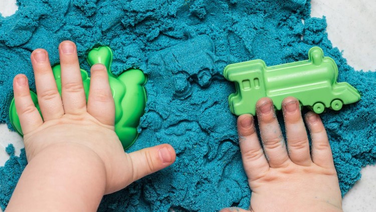 Сhild playing with blue kinetic sand