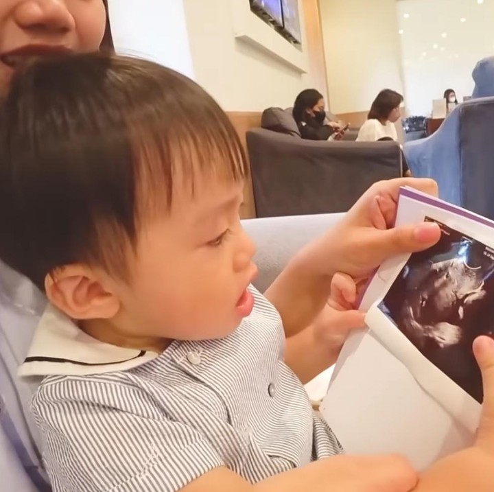 <p>Potret anak pertama mereka Hwani memandangi dan mencium foto USG adiknya juga sukses membuat gemas nih, Bunda. (Sumber: Youtube TaraWoni TV)</p>