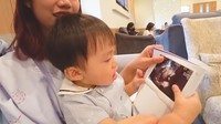 <p>Potret anak pertama mereka Hwani memandangi dan mencium foto USG adiknya juga sukses membuat gemas nih, Bunda. (Sumber: Youtube TaraWoni TV)</p>